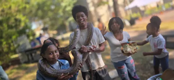 Kids at a party with a large snake