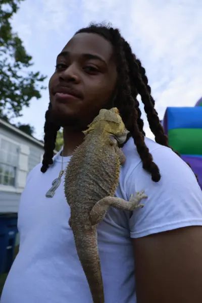 Man with a bearded dragon on his shoulder