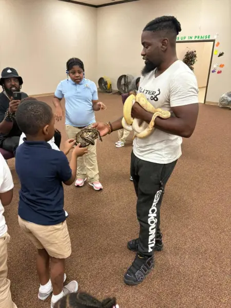 Child holding a snake at a school presentation