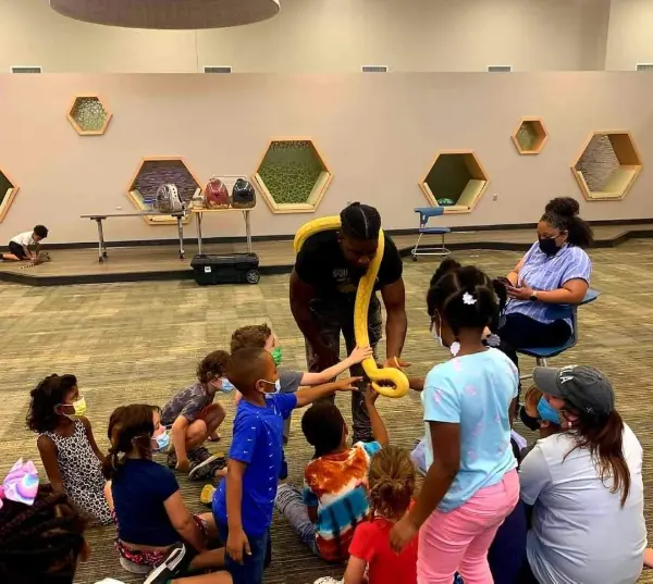 Solofa Halley with a Reticulated Python named Athena and children